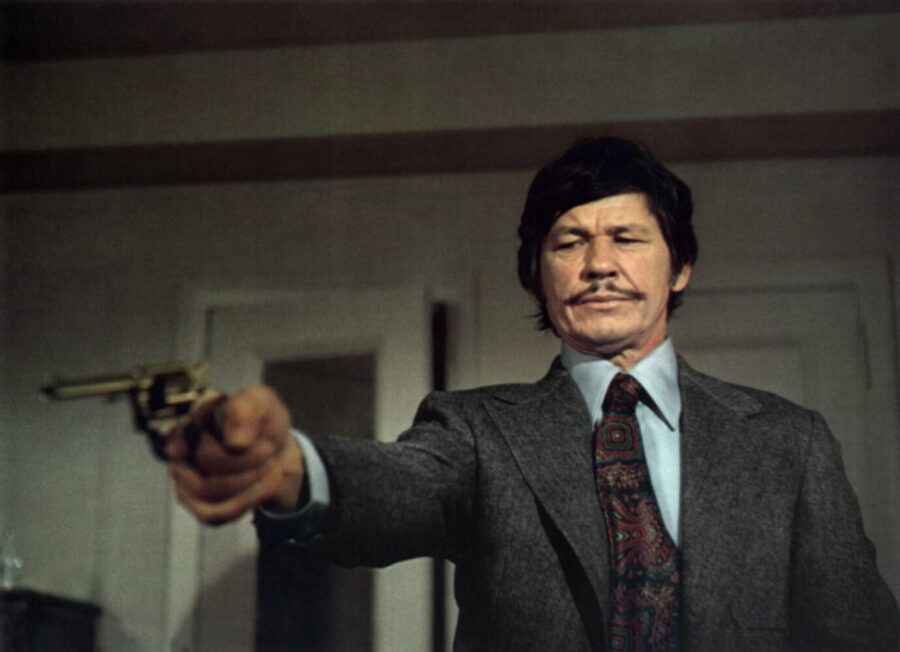 Vor fünfzig Jahren verändert „Ein Mann sieht rot“ mit Charles Bronson das deutsche Kino. Die Selbstjustiz-Masche zieht bis heute Zuschauer magisch an und konterkariert den Zeitgeist. Ein Mann sieht rot (Death Wish, USA 1974, Regie: Michael Winner) Charles Bronson / Mann mit Waffe, Pistole, zielen auf, bedrohen, Selbstjustiz, männlich, viril, martialisch Charles Bronson in „Ein Mann sieht rot“ von 1974: Die Geburtsstunde des Selbjustiz-Krimis. Foto: picture alliance / | -