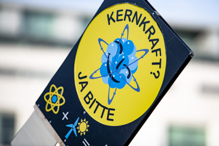 Ein Teilnehmer hält auf einer Demonstration des Vereins Nuklearia e.V. für den Erhalt von Atomkraft und Atomkraftwerken vor dem Brandenburger Tor ein Schild mit der Aufschrift "Kernenergie ja bitte" in die Höhe. Demonstration für die friedliche Nutzung der Kernenergie in Berlin: Eine US-Studie zeigt, Deutschland könnte seine Atomkraftwerke wieder anschalten. Foto: picture alliance/dpa | Fabian Sommer