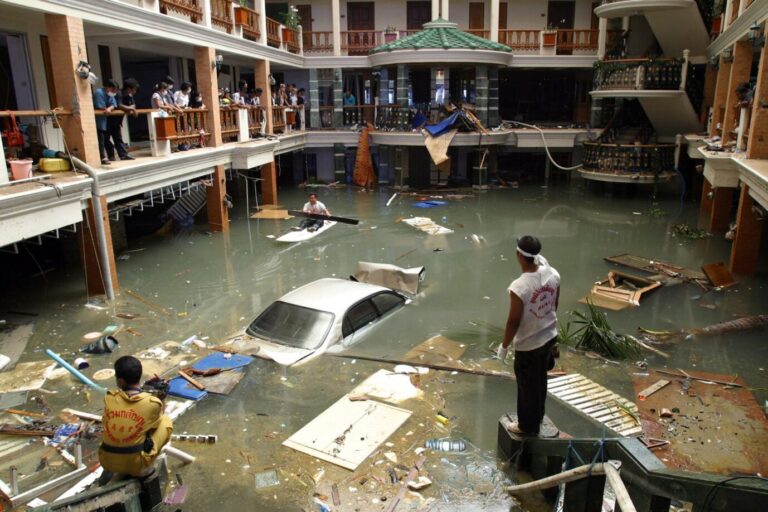 Rettungs- und Aufräumarbeiter begutachten eine überflutete Lobby des Seapearl Beach Hotels am Patong Beach auf der Insel Phuket, Thailand, in diesem Dateifoto vom 28. Dezember 2004, nachdem die massiven Tsunamiwellen die Küste überschwemmt hatten. Die Gesamtzahl der Toten und Vermissten des letztjährigen Tsunamis im Indischen Ozean beläuft sich nach Angaben der Regierung und der Hilfsorganisationen auf mindestens 216 858, obwohl die verschiedenen Organisationen in Indonesien und Sri Lanka unterschiedliche Zahlen melden. Es herrschte Panik. Rettungs- und Aufräumarbeiter begutachten eine überflutete Hotellobby: Der Tsunami vor 20 Jahren verwüstete die Insel Phuket. Foto: picture alliance / ASSOCIATED PRESS | Deddeda Stemler