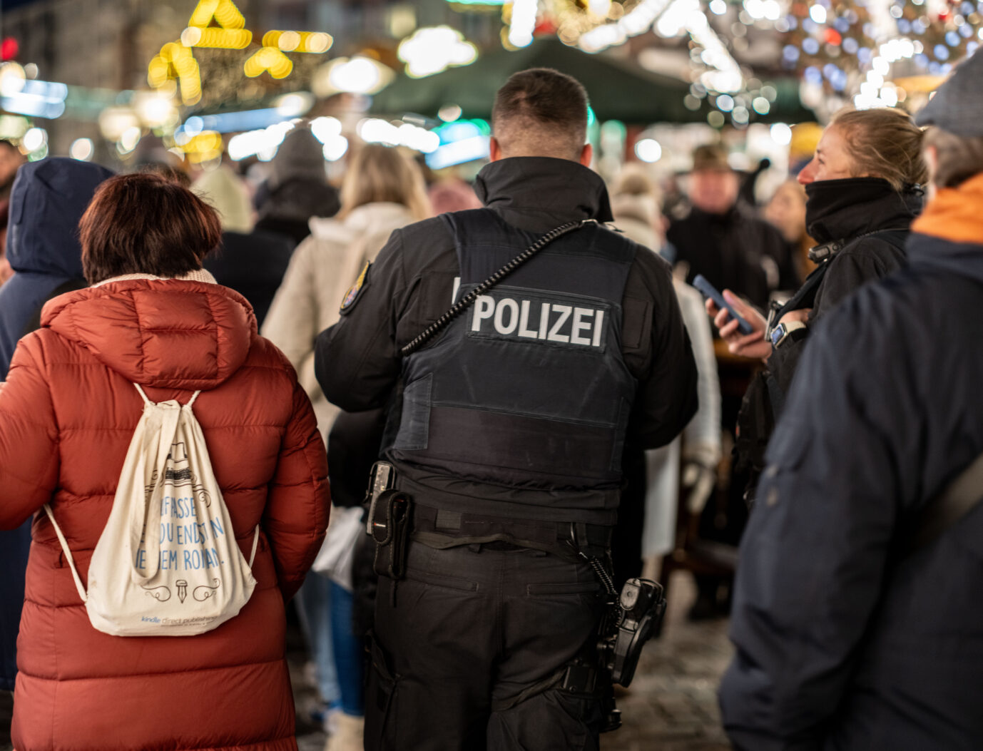 Polizisten gehen zwischen den Besuchern über den Frankfurter Weihnachtsmarkt auf dem Römerberg. Polizisten müssen den Frankfurter Weihnachtsmarkt sichern: Drei mutmaßliche IS-Terroristen wurden festgenommen. Foto: picture alliance/dpa | Frank Rumpenhorst