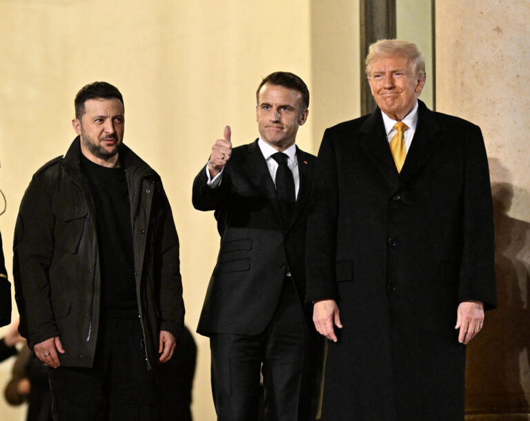 In Paris stehen der ukrainische Präsident Wolodimir Selenskyj, der französische Präsident Emmanuel Macron und der künftige US-Präsident Donald Trump, alle gekleidet in schwarze Anzüge, nebeneinander. Macron macht "Daumen hoch", Selenskyj schaut zur Seite, Trump grinst. Wie werden diese drei Herren über die Zukunft der Ukraine entscheiden