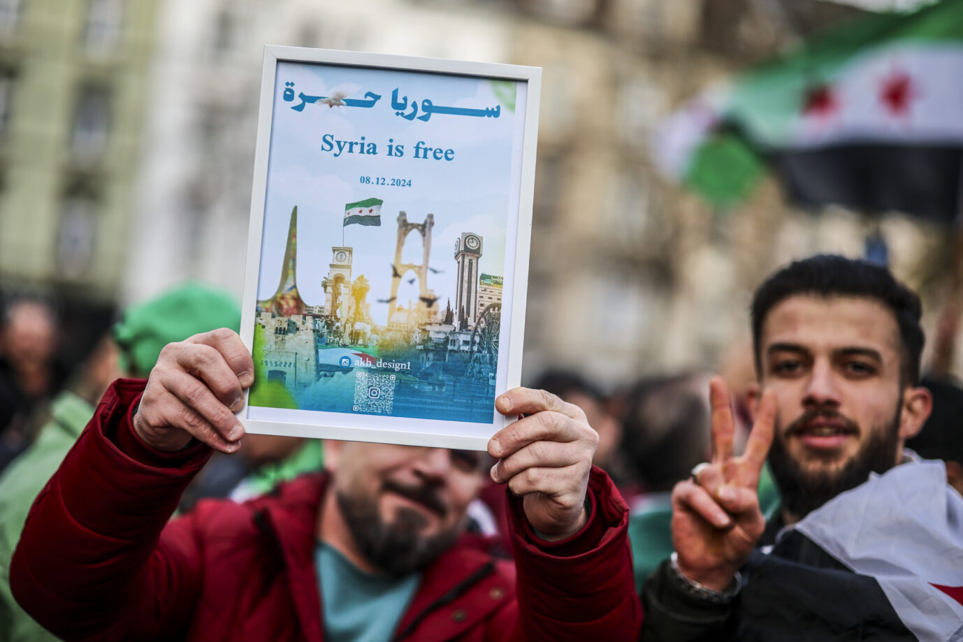 Ein Mann aus Syrien mit einem Schild mit dem Schriftzug Syria is free.