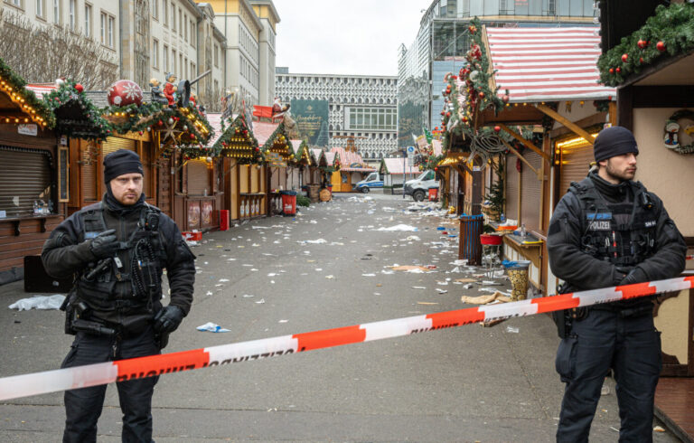 Polizisten stehen am Weihnachtsmarkt in Magdeburg (Foto vom 21.12.2024). Auf den Weihnachtsmarkt in der Innenstadt von Magdeburg ist am Freitagabend (20.12.2024) ein mutmasslicher Anschlag veruebt worden. Ein Auto war in die Menschenmenge auf dem Weihnachtsmarkt gerast. Laut Polizei fuhr der Taeter "mindestens 400 Meter ueber den Weihnachtsmarkt". Bislang starben fuenf Menschen bei dem Anschlag, darunter ein Kleinkind. Mehr als 200 wurden verletzt, viele davon schwer. Der mutmassliche Taeter ist ein seit 2006 in Deutschland lebender Arzt aus Saudi-Arabien. (Siehe epd-Meldung vom 21.12.2024)