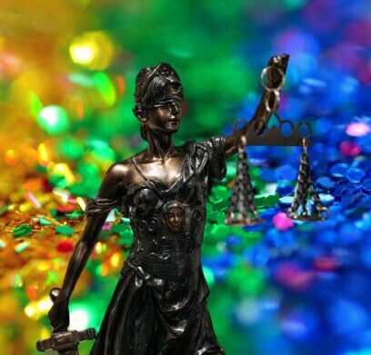 Das Selbstbestimmungsgesetz macht einer Transperson 239 Klagen pro Jahr möglich. Justitia vor einem glitzernden Regenbogen. (Symbolbild): Pexels (x2)