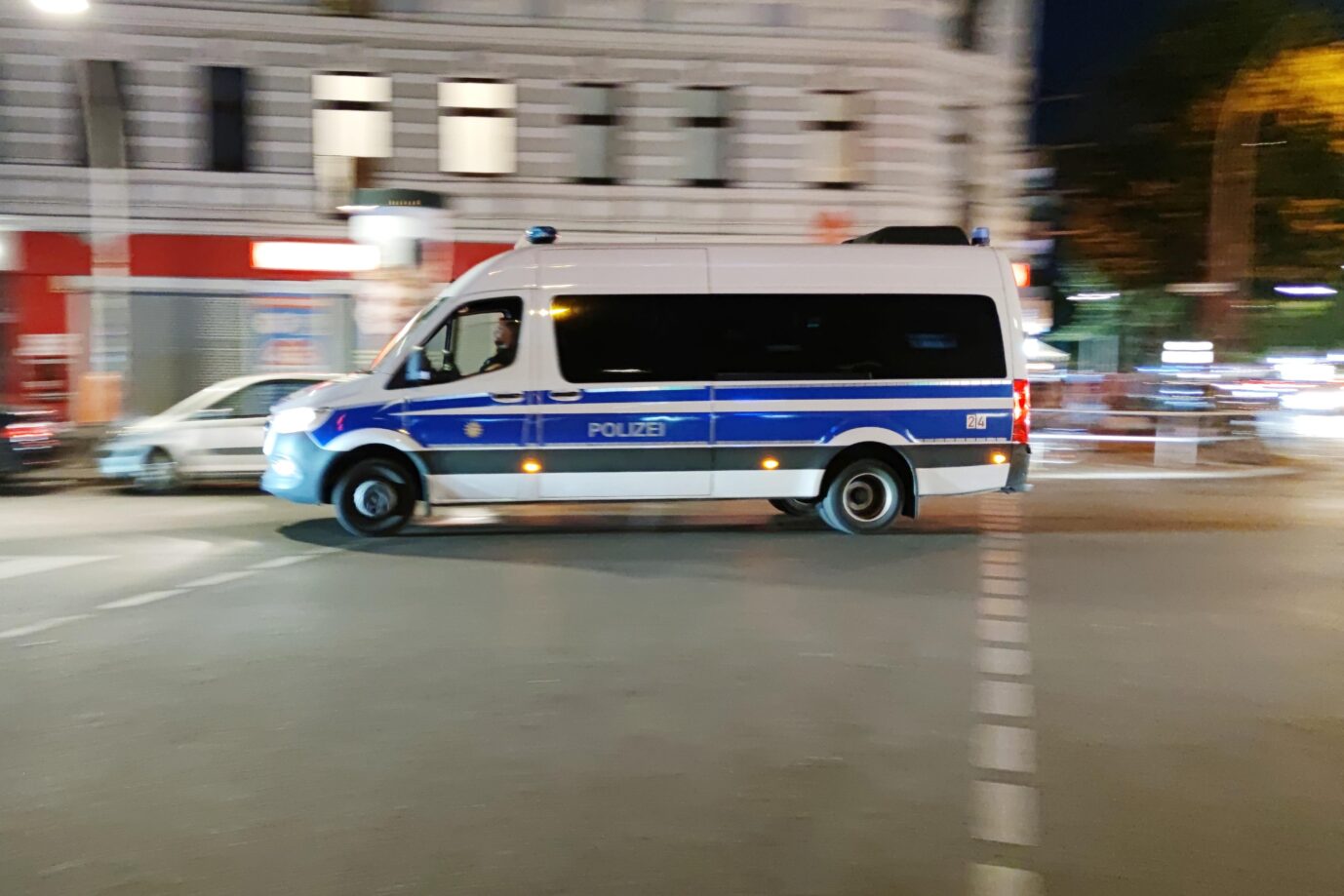 Ein blau-weißes Fahrzeug der Berliner Polizei rast eine Straße entlang. Ein Syrer wurde verhaftet.