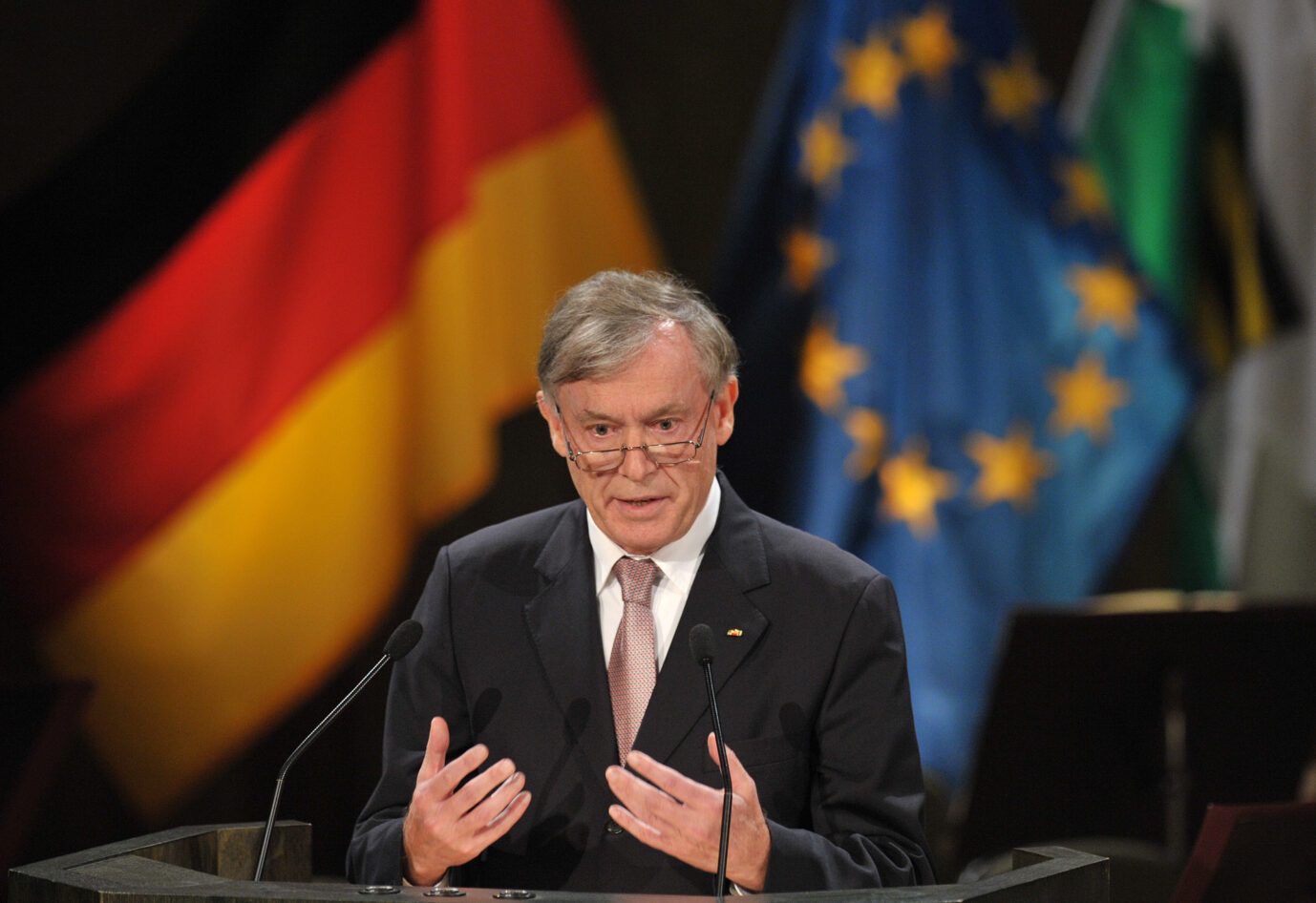 Der ehemalige Bundespräsident Horst Köhler steht vor einer Deutschlandflagge und einer EU-Flagge, während er 2009 eine Rede hält