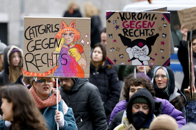 Zwei Frauen halten Schilder mit den Aufschriften "Catgirls gegen Rechts" und "Kuromi gegen rechts" hoch – Sinnbilder für den linken totalitären Geist, der sich gegen Freiheit engagiert