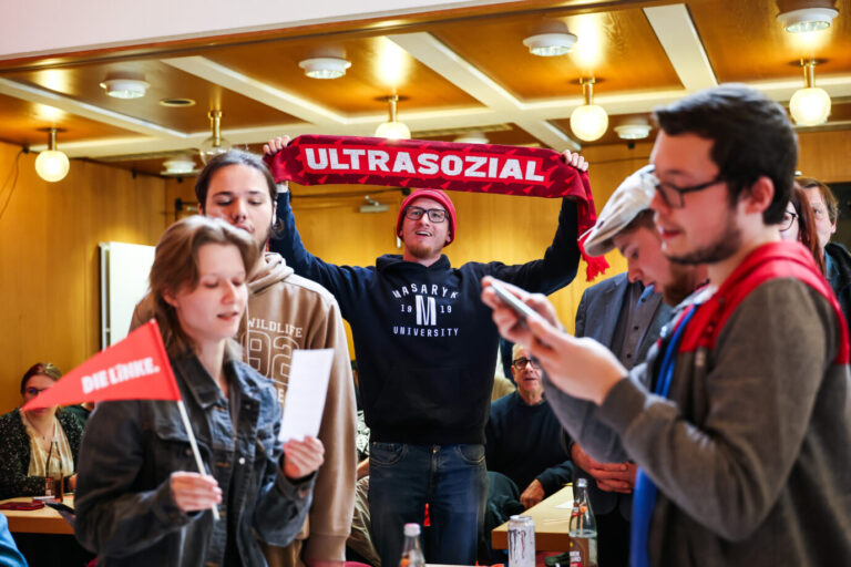 Parteimitglieder und Unterstützer der Linkspartei singen am Ende des Politischen Aschermittwochs der Linke und halten einen Schal mit der Aufschrift „Ultrasozial“ in die Höhe.