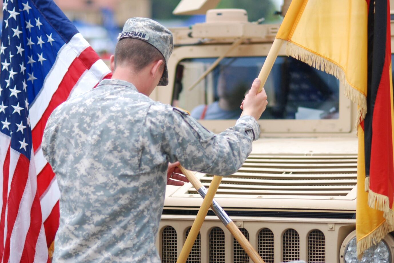 Soldat der USA in Deutschland mit deutscher und amerikanischer Flagge: Viele sehen das Verhältnis als feindlich. Foto: IMAGO / Stefan Noebel-Heise. Neue Insa-Umfrage erschienen.