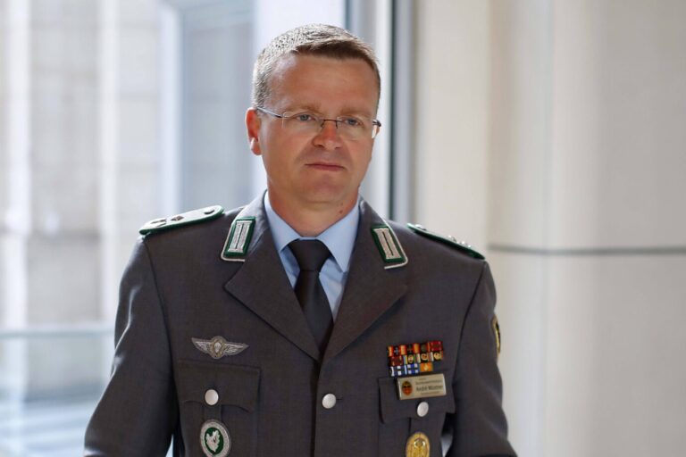 Der Vorsitzende des Deutschen Bundeswehrverbands, André Wüstner, steht in grauer Uniform da und schaut grimmig