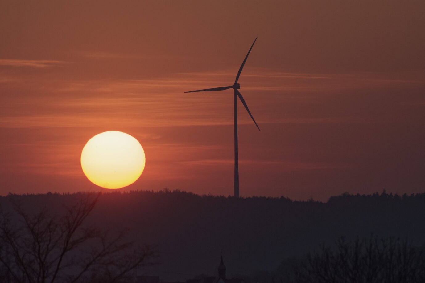 Ein Windrad steht im Sonnenuntergang – in Baden-Württemberg, ein Symbolbild für die grüne Energiewende