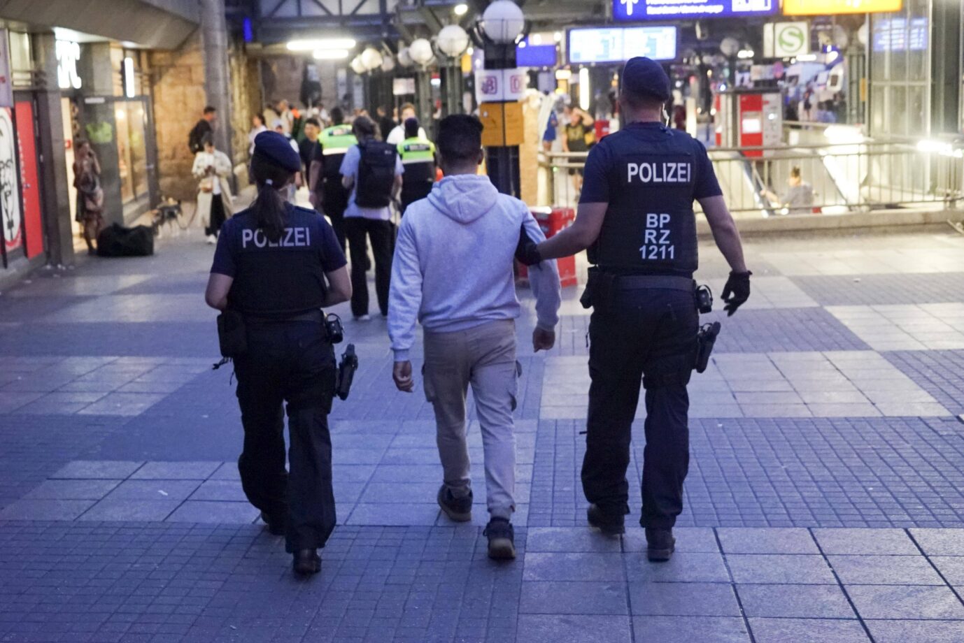 Ein Mann wird von der Polizei eskortiert. Die Kriminalität in Brandenburgs öffentlichem Nahverkehr steigt. Täter sind oft Ausländer.