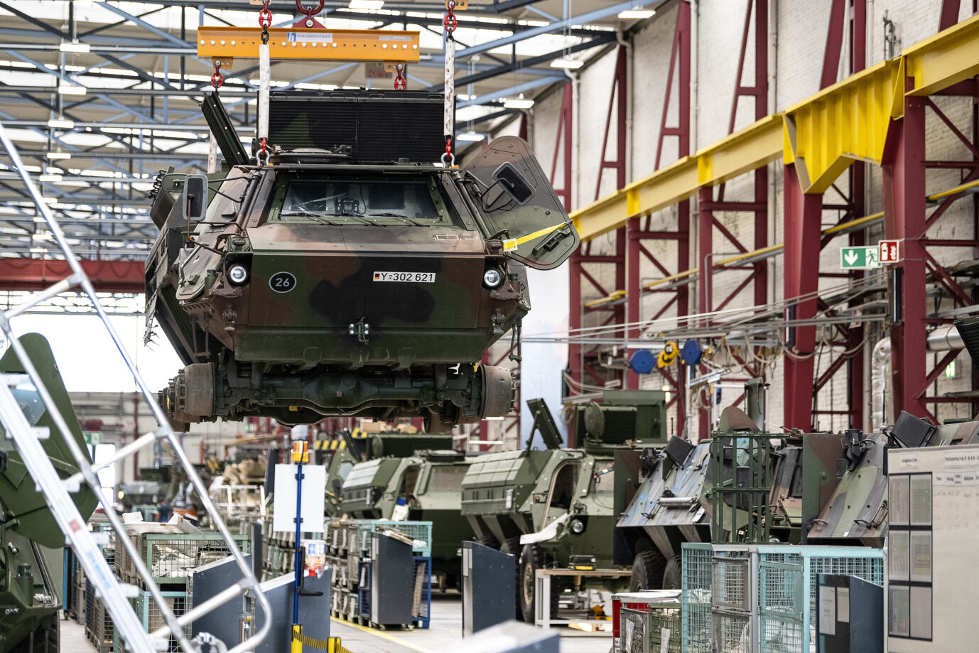 Ein Panzer vom Typ Fuchs schwebt in der Fertigungshalle von Rheinmetall. Rhein informiert sich über die Aktivitäten und Projekte des Unternehmens am Standort Kassel. Die Bundeswehr will aufrüsten.