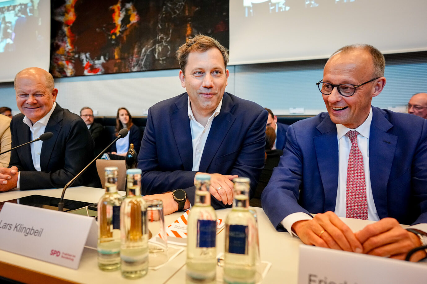 Der designierte Bundeskanzler Friedrich Merz (CDU, rechts) mit seinem Vorgänger Olaf Scholz (SPD, links) und SPD-Chef Lars Klingbeil am Montag bei der SPD-Fraktion.