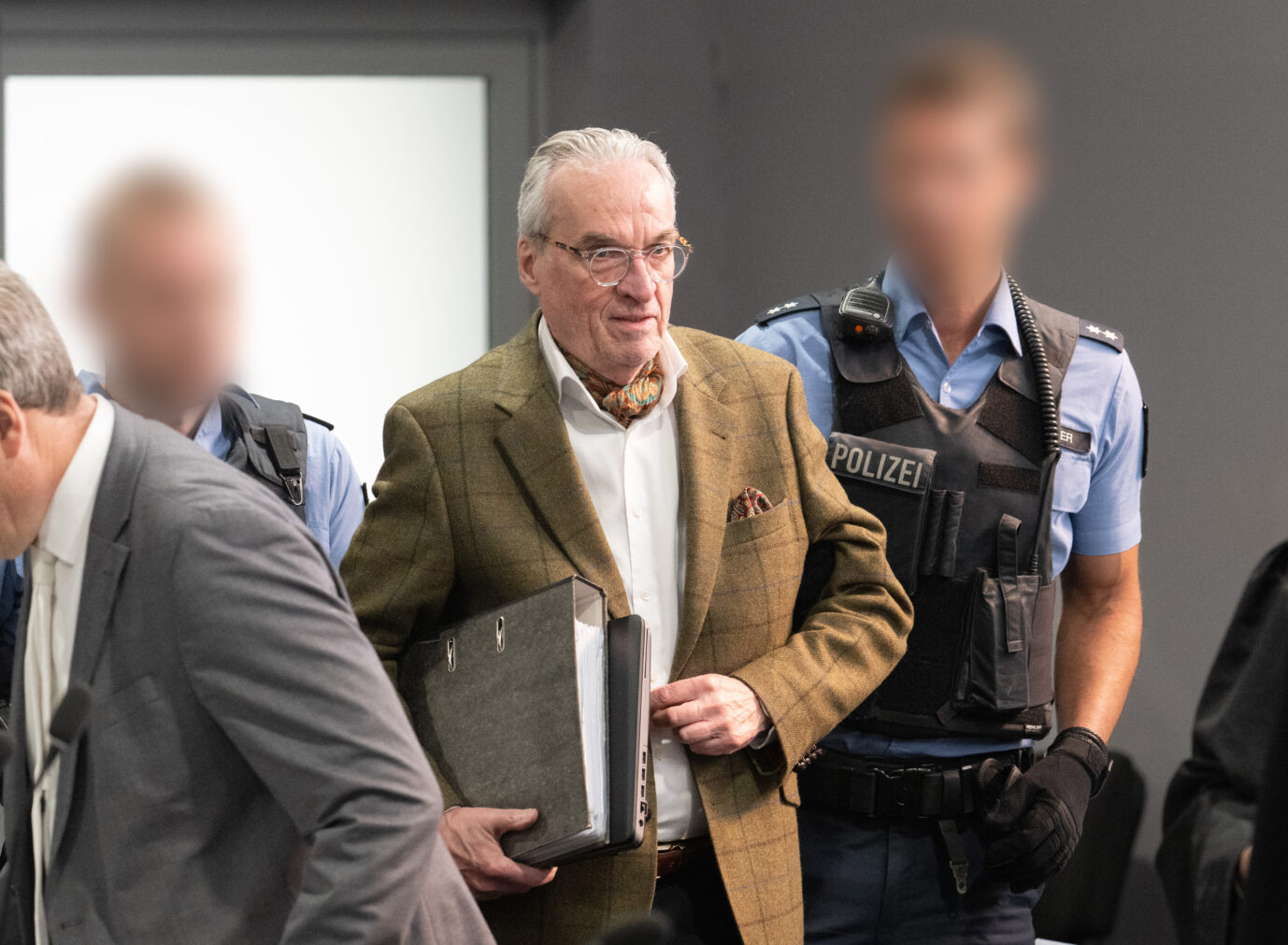 Der Hauptangeklagte Heinrich der XIII. Prinz Reuß (M) kommt von Polizisten gebracht in den Verhandlungssaal im Oberlandesgericht Frankfurt, Außenstelle im Stadtteil Sossenheim. Die Bundesanwaltschaft legt den neun Angeklagten zur Last, Mitglied in einer terroristischen Vereinigung gewesen zu sein. Ziel der Gruppe sei es gewesen, die bestehende staatliche Ordnung in Deutschland gewaltsam zu beseitigen. Im Volksmund wird die Verhandlung auch „Reichsbürger-Prozeß“ genannt.