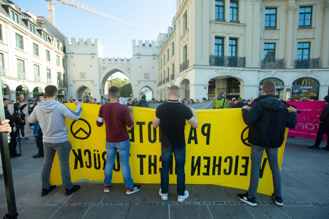 Mehrere Mitglieder der Identitären Bewegung halten während einer Demonstration im Jahre 2019 ein Banner in den Farben gelb und schwarz hoch – nun wurden mehrere Mitglieder mit Ausreiseverboten belegt