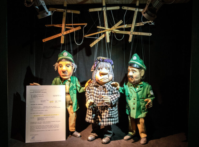 Polizeimarionetten führen den Kirchenorganisisten Quallus in Handschellen ab. Im Museum der Augsburger Puppenkiste werden Marionetten und Handpuppen in der Sonderausstellung «Gesucht wird ... Kriminalgeschichten auf der Puppenbühne» inszeniert. In Berlin steht ein Kindertheater vor dem Aus.