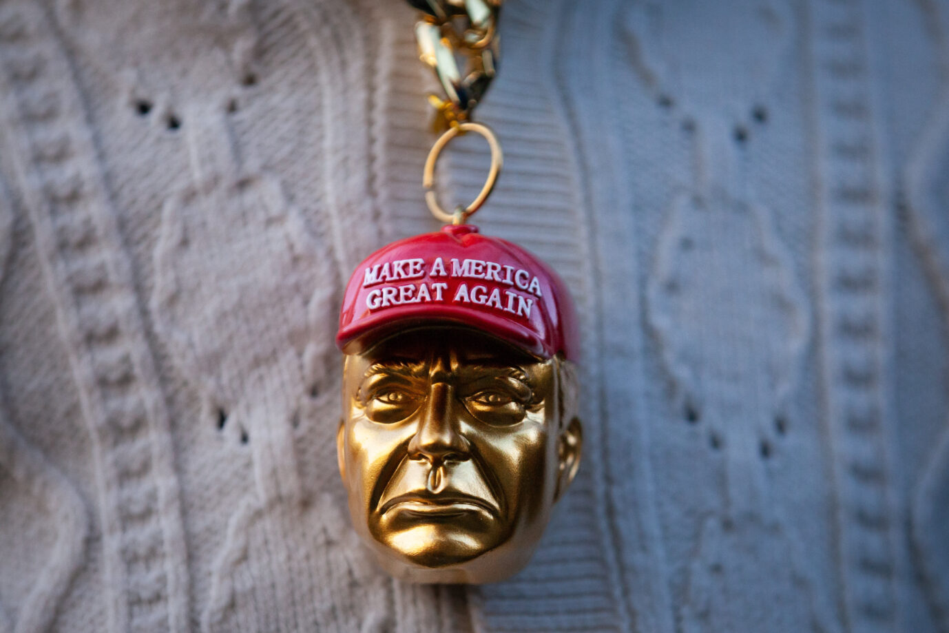 A man wears a necklace with an enormous golden likeness of Donald Trump in a red MAGA hat in Washington, DC, on January 20, 2025. Trump was inaugurated as the 47th President of the United States, despite his felony convictions and indictments for the January 6, 2021 Capitol insurrection and obstruction of a classified documents investigation. (Photo by Allison Bailey/NurPhoto)