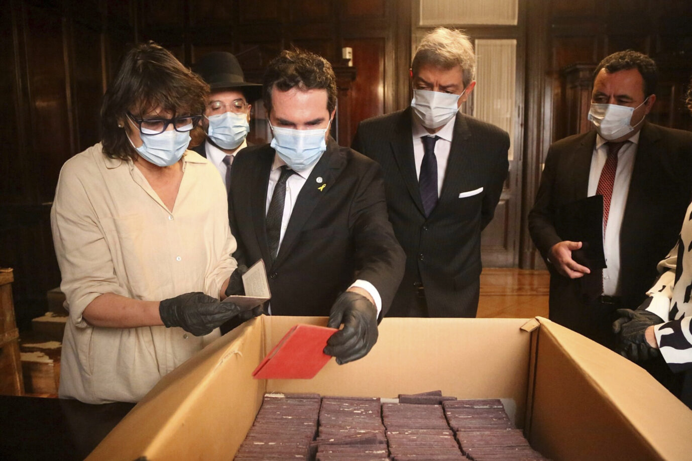 Auf diesem vom Obersten Gerichtshof Argentiniens am Sonntag, dem 11. Mai 2025, veröffentlichten Foto sind von links nach rechts zu sehen: die Wissenschaftlerin Marcia Ras, der Rabbiner Eliahu Hamra, der Direktor des Holocaust-Museums von Buenos Aires, Jonathan Karszenbaum, der Präsident des Obersten Gerichtshofs, Horacio Rosatti, und Pablo Lamounat, der Direktor des Centro de Asistencia Judicial Federal, bei der Durchsicht von Dokumenten, die mit dem Naziregime in Verbindung stehen und in Kisten aufbewahrt werden, die Mitarbeiter des Gerichtsarchivs in Buenos Aires, Argentinien, bei den Vorbereitungen für ein Museum mit historischen Aufzeichnungen gefunden haben. (Oberster Gerichtshof Argentiniens via AP)