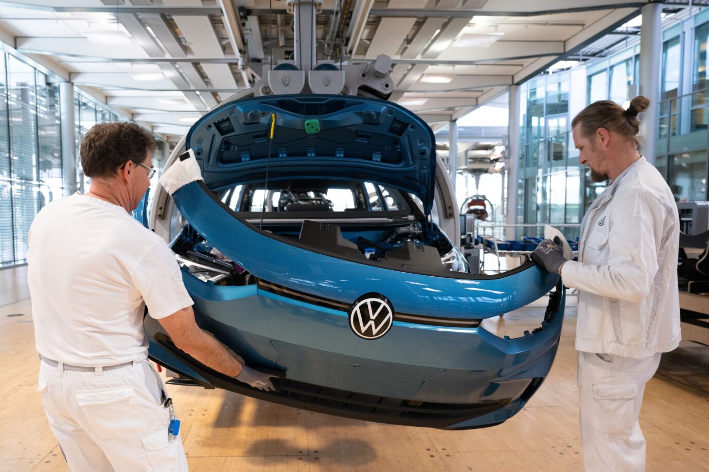Volkswagen-Mitarbeiter montieren die Karosserie eines E-Autos.