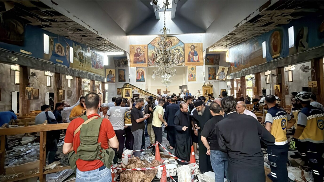 Man sieht eine Menschenmenge in einer Kirche steheh – es handelt sich um die stark zerstörte orthodoxe Elias-Kirche in der syrischen Hauptstadt Damaskus nach einem islamistischen Bombenanschlag – nicht der erste seiner Art in Syrien