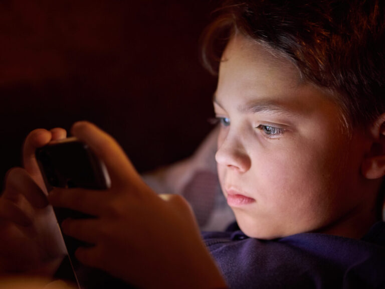 Ein Junge spielt mit einem Handy. Thema der Meldung: Sprachstörungen bei Kindern und Jugendlichen. Ist das Handy schuld?