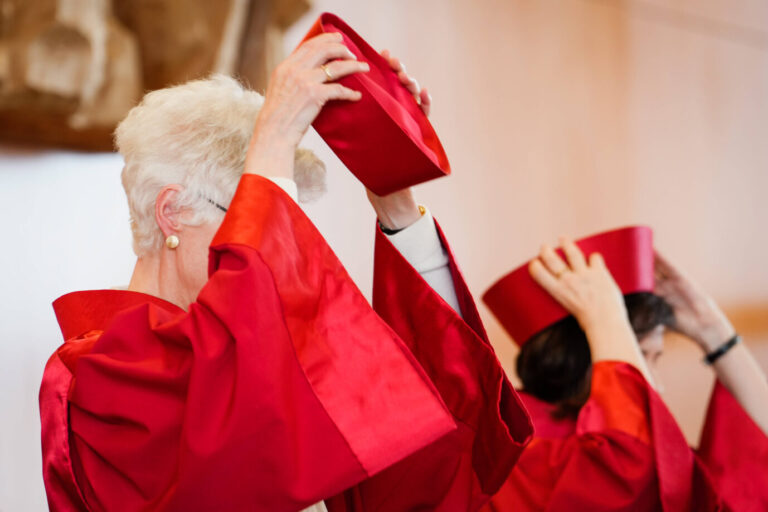 Zwei Richterinnen des Bundesverfassungsgerichts setzen sich bei Beginn einer Sitzung ihre traditionelle rote Kopfbedeckung auf. Sie tragen rote Roben, wie sie für Verfassungsrichter in Karlsruhe vorgeschrieben sind. Das Bild zeigt den feierlichen Moment aus nächster Nähe. Urteilsverkündung beim Bundesverfassungsgericht: Karlsruhe lehnt Klagen der AfD restlos ab. Foto: IMAGO / Political-Moments