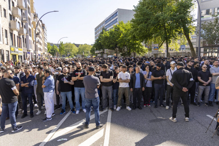 Eine große Menschenmenge steht dicht gedrängt auf einer innerstädtischen Straße bei Sonnenschein. Fast ausschließlich junge Männer, viele mit verschränkten Armen, richten den Blick nach vorn. Im Vordergrund stehen mehrere Männer in Gesprächsposition. Im Hintergrund sind Bäume, Wohnhäuser und Arztpraxen zu sehen. Eine neue Untersuchung wirft ein Schlaglicht auf innerislamische Konflikte: Viele Muslime in Deutschland befürworten autoritäre und gewaltlegitimierende Positionen. Die Gründe dafür sind vielfältig. Radikale Muslime demonstrieren am Hamburger Steindamm: Eine Studie klärt über das Gefährdungspotential auf. Foto: Foto: IMAGO / Markus Matzel