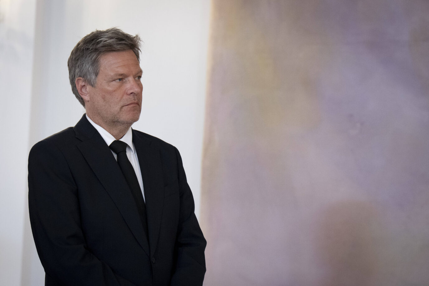 Ex-Vizekanzler Robert Habeck steht in dunklem Anzug und schwarzer Krawatte mit ernstem Blick vor einer hellen Wand mit pastellfarbenem Farbverlauf: Aufnahme während der feierlichen Übergabe der Entlassungsurkunden durch Bundespräsident Frank-Walter Steinmeier an die Bundesregierung im Schloss Bellevue in Berlin. Der frühere Wirtschaftsminister Robert Habeck (Grüne) beim Bundespräsidenten: Schwerwiegende Vorwürfe der Rechnungsprüfer. Foto: Foto: IMAGO / Bernd Elmenthaler