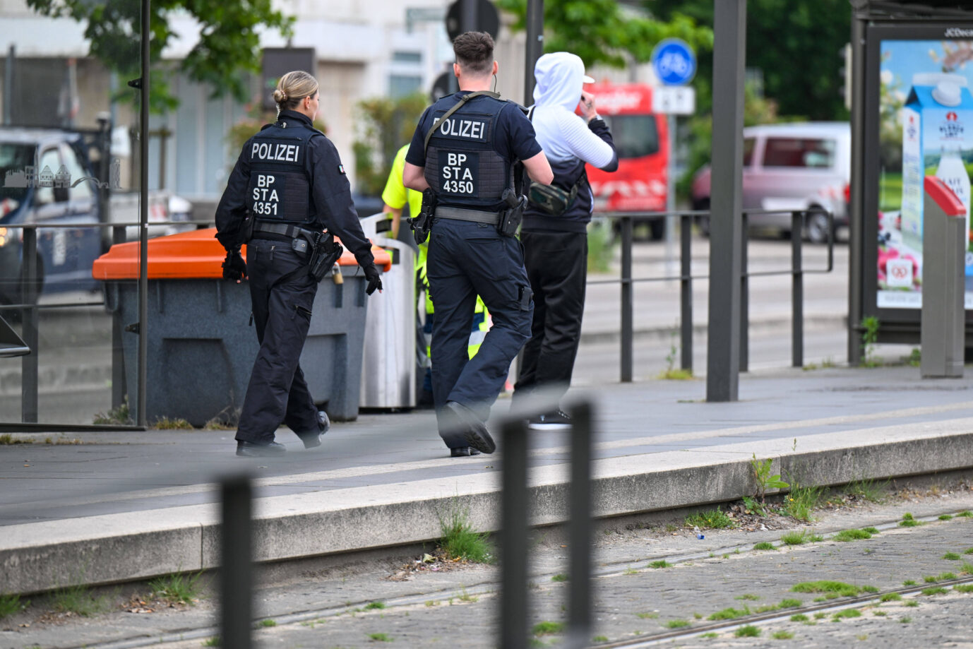 Zwei Bundespolizisten führen eine Person mit Kapuzenpullover an einer Straßenbahnhaltestelle ab. Die Polizisten tragen Schutzwesten mit der Aufschrift „BP STA“. Im Hintergrund sind weitere Personen und Fahrzeuge zu sehen. Bundespolizei im Einsatz, Eine Kontrollstelle am deutsch-französischen Grenzübergang bei Kehl. Die verschärften Grenzkontrollen werden zur Belastungsprobe für die Polizei. Laut Gewerkschaft der Polizei (GdP) lassen sich die Kontrollen nur noch wenige Wochen durchhalten. Kehl Baden-Württemberg Deutschland Kehl