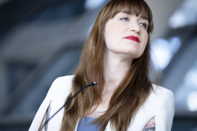 Heidi Reichinnek, Fraktionsvorsitzende der Linken im Bundestag, steht an einem Rednerpult und blickt entschlossen zur Seite. Sie trägt eine weiße Jacke, ihr langes braunes Haar fällt offen über die Schultern. Die Aufnahme entstand im politischen Kontext und zeigt sie im Profil mit ernstem Gesichtsausdruck. Linken-Fraktionschefin Heidi Reichinnek droht der Union offen mit Blockade – sie will mit allen Mitteln ins Kontrollgremium. Foto: IMAGO / Bernd Elmenthaler