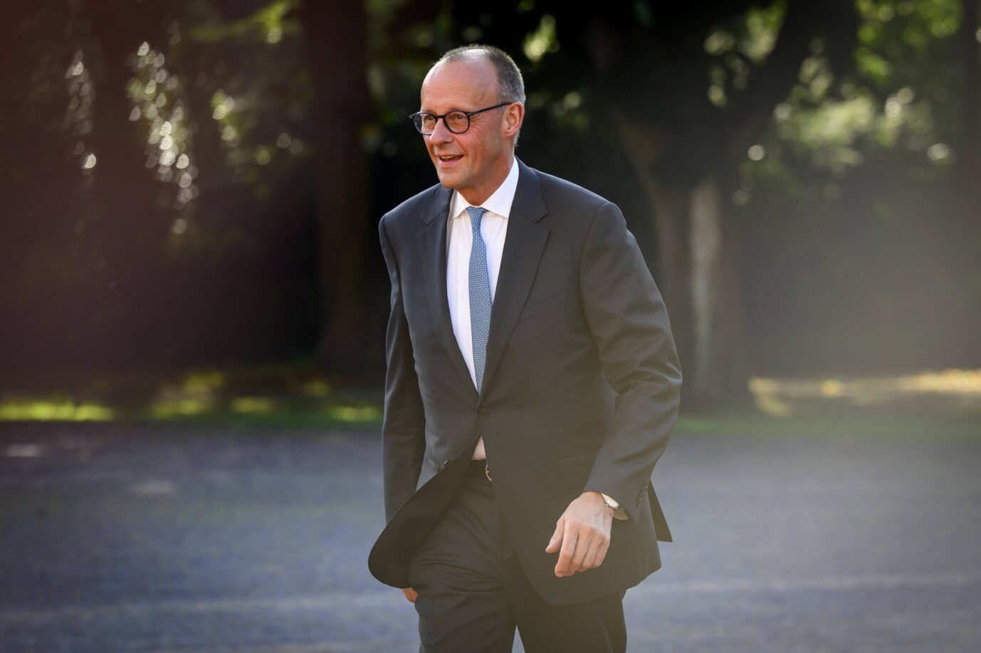 Friedrich Merz, Bundeskanzler und CDU-Vorsitzender, im Anzug mit blauer Krawatte bei einem öffentlichen Auftritt im Freien. Er geht lächelnd über einen Platz, im Hintergrund Bäume und Schatten. Das Bild wurde bei Tageslicht aufgenommen. CDU-Chef Friedrich Merz baut den Vorsprung seiner Partei zur AfD aus – und verbessert sich in der Wählergunst. Foto: IMAGO / NL Beeld