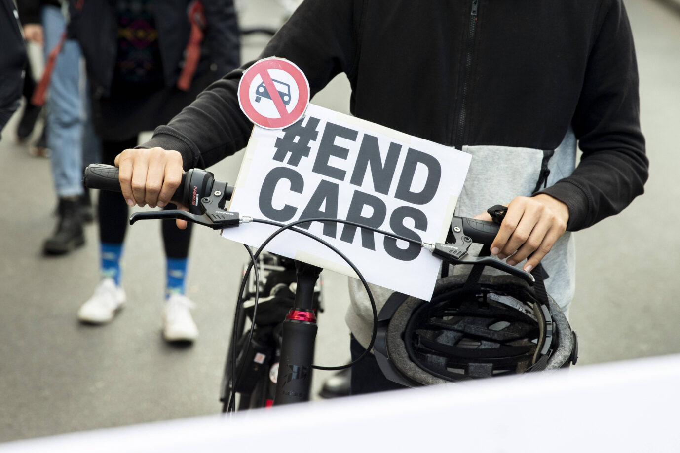 Eine Linksextremistin von "Berlin autofrei" mit einem Fahrrad und Schild "EndCars". Das Volksbegehren ist rechtmäßig.