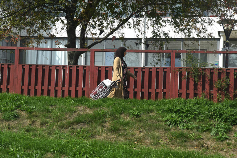 Eine Frau mit Kopftuch – offensichtlich Migrantin – läuft durch ein Wohngebiet im schwedischen Malmö, im Hintergrund sieht man einen Wohnblock – Symbolbild dafür, daß die schwedischen Sozialdemokraten Asylbewerber künftig vor allem in wohlhabenden Vierteln unterbringen wollen, um die Entstehung von Ghettos zu vermeiden