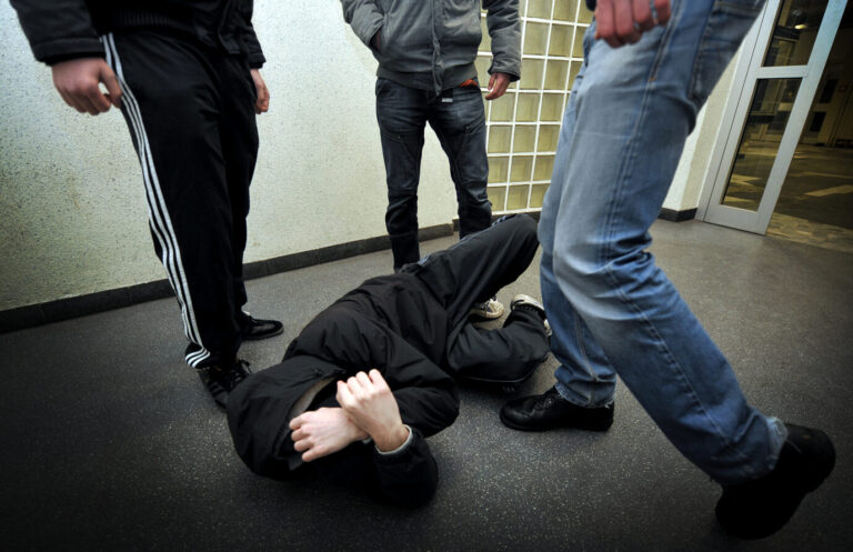 Ein junger Mann liegt schutzlos am Boden, während ihn mehrere Jugendliche umringen. Einer hebt gerade den Fuß zum Tritt an. Die Szene spielt sich in einem Innenbereich mit kahler Wand und Glasbausteinen ab. Der Angriff wirkt brutal und gezielt, die Gesichter der Täter sind nicht sichtbar. Angriff mit Tritten auf Jugendlichen: In Harsefeld wurden vergleichbare Szenen gefilmt. Weil der Staat im Kampf gegen eine Jugendbande versagt, gründet sich im niedersächsischen Harsefeld eine Bürgerwehr. Doch auch über diese Entwicklung ist die Polizei nicht erfreut. Foto: IMAGO / Funke Foto Services