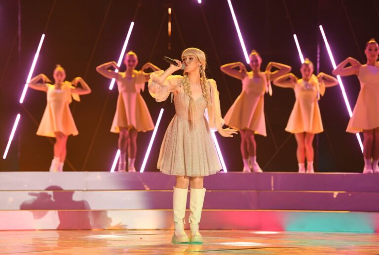 Auf einer Bühne steht eine cute osteuropäische Frau mit Zöpfen – es handelt sich um die weißrussische Sängerin Anastasia Krawtschenko, diem am 20. September beim Intervision Song Contest in Moskau antreten wird