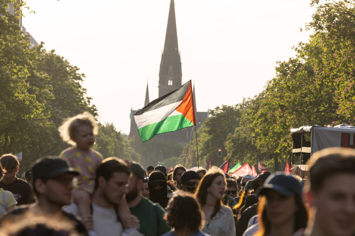 Eine Palästina-Demonstrantin wurde für Angriffe auf die Polizei verurteilt. Das Skandieren eines Hamas-Slogans blieb dagegen folgenlos. Teilnehmer einer Demonstration ziehen mit palästinensischen Fahnen durch eine Berliner Straße. Im Hintergrund ist die Kirche am Südstern zu sehen. Die Aufnahme entstand am 1. Mai 2024 bei der „Revolutionären 1. Mai-Demo“ in Berlin. Palästina-Fahne bei einer Berliner Demo: Der Slogan „From the river to the sea“ bleibt für eine Angeklagte straffrei. Foto: IMAGO / Eibner