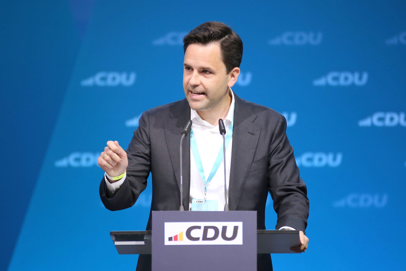 Vor einem blauen Hintergrund steht der Vorsitzende der Jungen Union, Johannes Winkel, und gestikuliert – vielleicht erklärt er gerade, wieso er keinen Boomer-Soli will