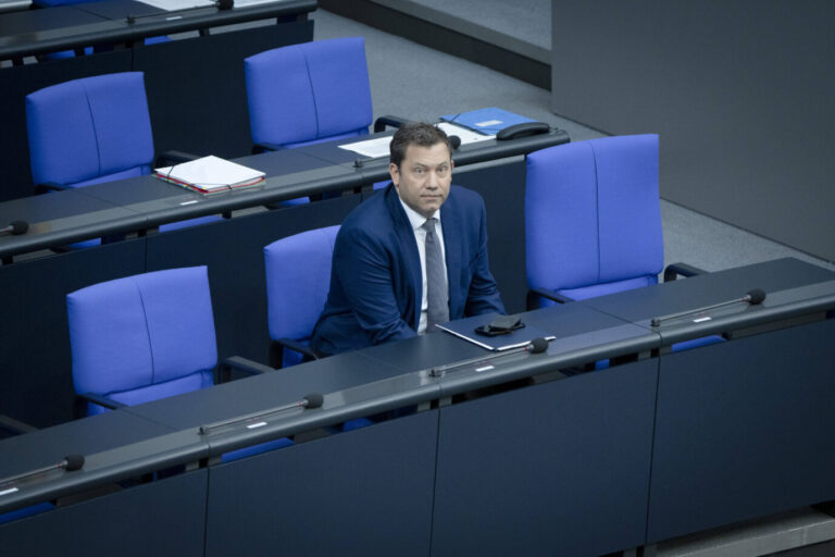 Ein Mann in dunkelblauem Anzug und grauer Krawatte sitzt allein in einer fast leeren Sitzreihe mit blauen Polsterstühlen in einem modernen Parlamentsraum. Vor ihm liegen ein Smartphone, ein Aktenhefter und mehrere Mikrofone auf dem Tisch. Die Atmosphäre wirkt nüchtern, der Raum funktional gestaltet. Es handelt sich um Lars Klingbeil, Bundesminister der Finanzen, während einer Sitzung im Deutschen Bundestag. Bundesfinanzminister Lars Klingbeil im Bundestag: Die Löcher in den Sozialkassen füllt der Sozialdemokrat derzeit mit neuen Darlehen. Foto: IMAGO / Bernd Elmenthaler