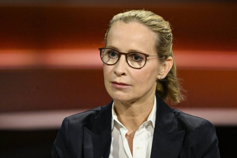 Frau mittleren Alters mit zusammengebundenem blonden Haar, Brille und dunklem Blazer sitzt in einem Fernsehstudio vor rot getöntem Hintergrund und blickt ernst nach vorn. Frauke Brosius-Gersdorf in einer Talksendung: Die SPD-Kandidatin für das Bundesverfassungsgericht relativiert die Menschenwürde ungeborener Kinder. Foto: IMAGO / teutopress