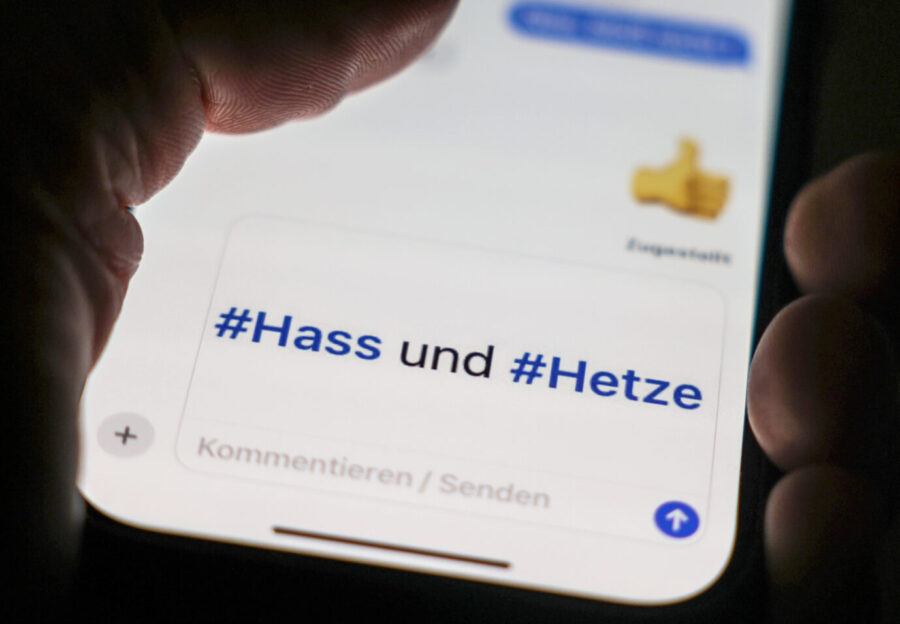 Das Foto zeigt ein Smartphone mit dem Schriftzug „Haß und Hetze“ und soll die Arbeit der Meldestellen in Deutschland symbolisieren.