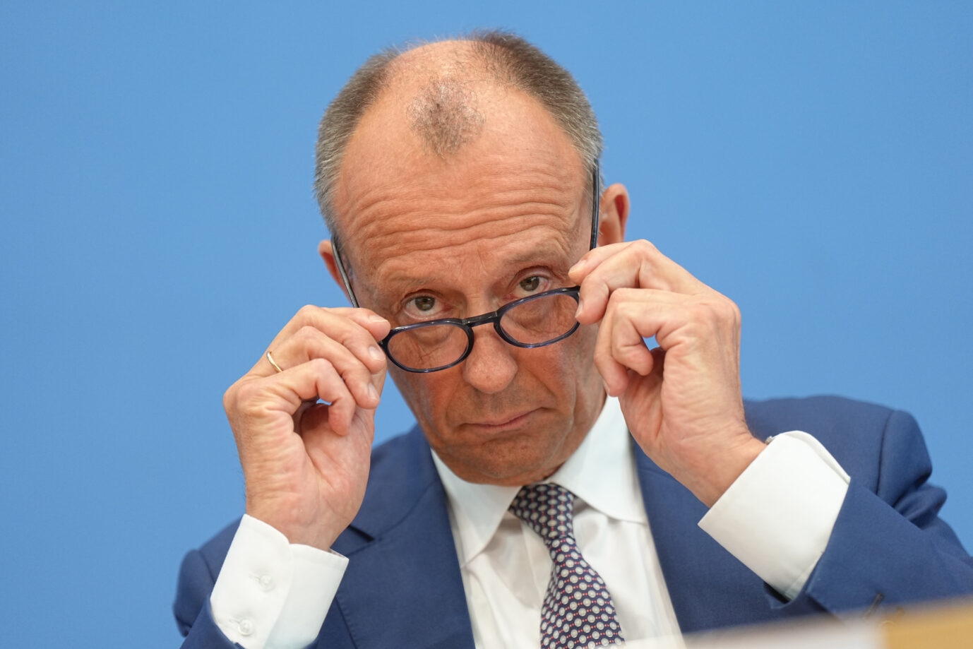 Bundeskanzler Friedrich Merz (CDU) sitzt bei seiner Sommer-Pressekonferenz in der Bundespressekonferenz und fasst an seine Brille. Merz führt die Tradition der Sommer-Pressekonferenzen der Bundeskanzler fort. Er wird eine erste Zwischenbilanz ziehen und Fragen zur Innen- und Außenpolitik beantworten.