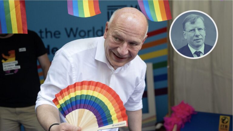 Berlins Bürgermeister Kai Wegner (CDU) posiert vor einigen Regenbogenfahnen und hält auch selbst eine in seiner Hand