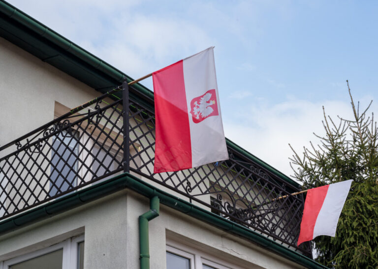 Die Flagge Polens auf einem Balkon (Symbolbild): Das Land lockt Rückkehrer unter anderem mit steuerlichen Anreizen.