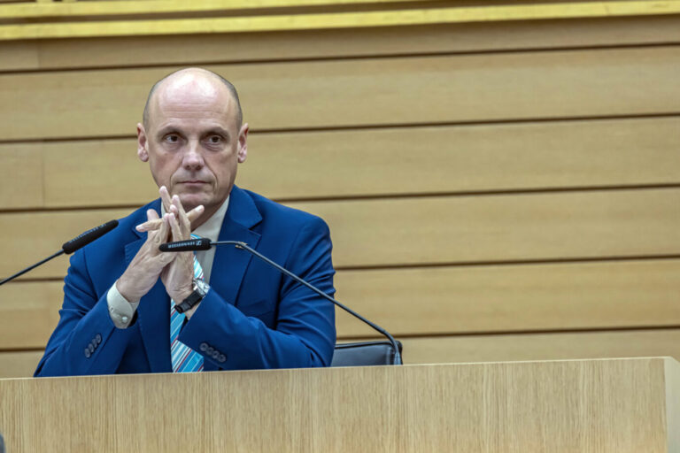 Ein Mann in blauem Anzug und gestreifter Krawatte sitzt an einem Rednerpult mit zwei Mikrofonen in einem Plenarsaal und hat die Hände vor sich verschränkt. Hakenkreuzkritzler Daniel Born in seiner Rolle als Landtagsvizepräsident von Baden-Württemberg: keine Ermittlungen gegen den Sozialdemokraten. Foto: IMAGO / Arnulf Hettrich