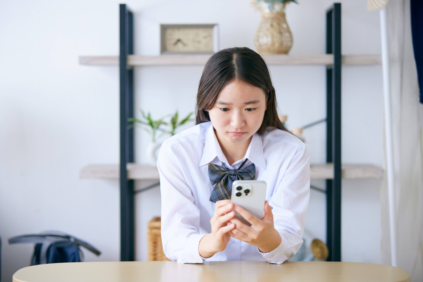 Ein japanisches Mädchen mit ihrem Smartphone: Im Land der aufgehenden Sonne leiden 1,5 Millionen Menschen an Einsamkeit. KI-Chatbots sollen diesen Schmerz lindern. (Themenbild/Symbolbild)