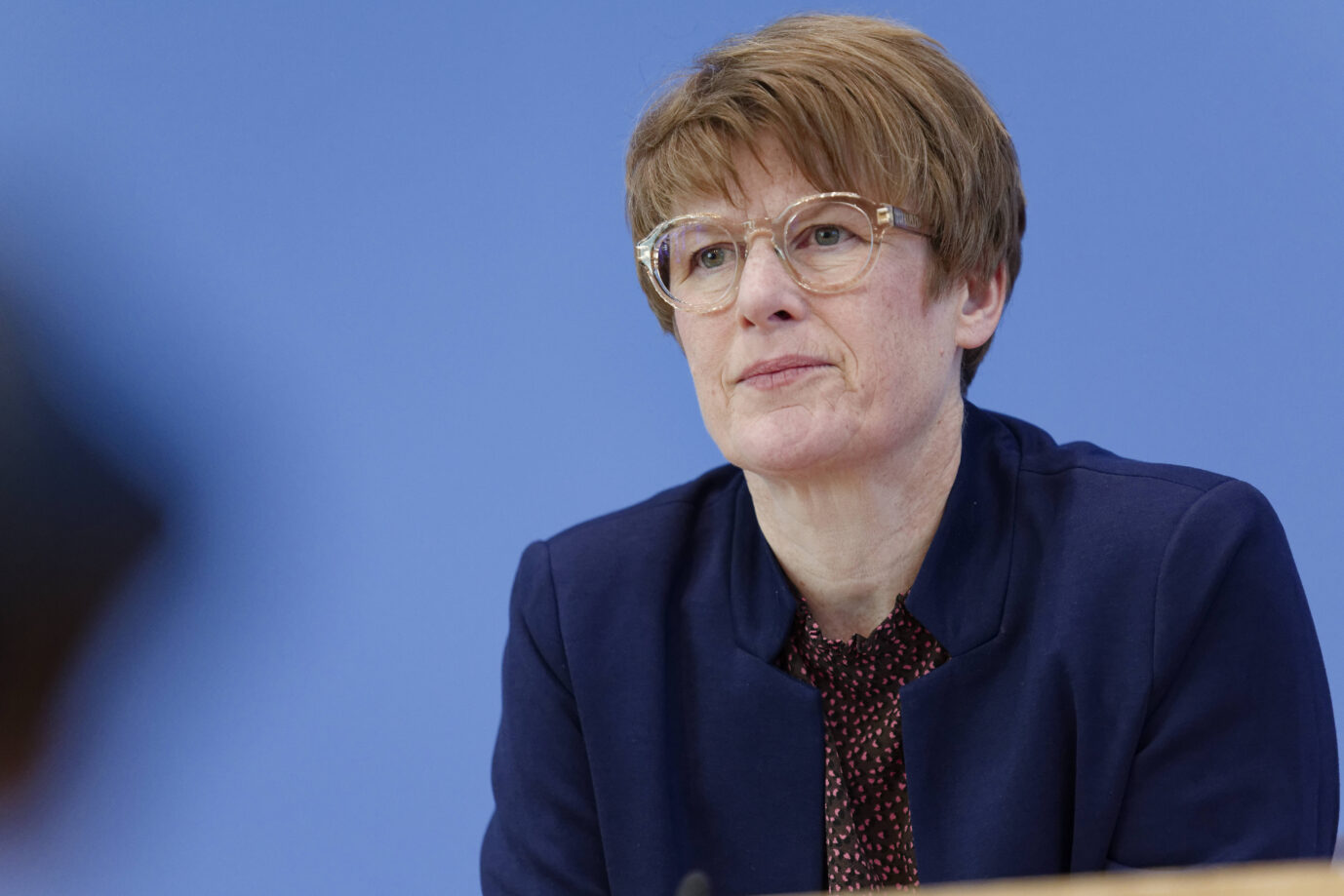 Sagt etwas zu den Sozialversicherungen: Prof. Dr. Veronika Grimm, Mitglied des Sachverständigenrats zur Begutachtung der gesamtwirtschaftlichen Entwicklung, sitzt bei der Vorstellung des Frühjahrsgutachtens 2025 in der Bundespressekonferenz in Berlin und blickt nachdenklich zur Seite. Sie trägt eine Brille, ein dunkelblaues Jackett und eine gemusterte Bluse, der Hintergrund ist blau. Die Wirtschaftsweise Veronika Grimm bei einer Pressekonferenz: Fordert „mehr Ehrlichkeit darüber, welche Leistungen wir uns leisten können“. Foto: IMAGO / Jürgen Heinrich