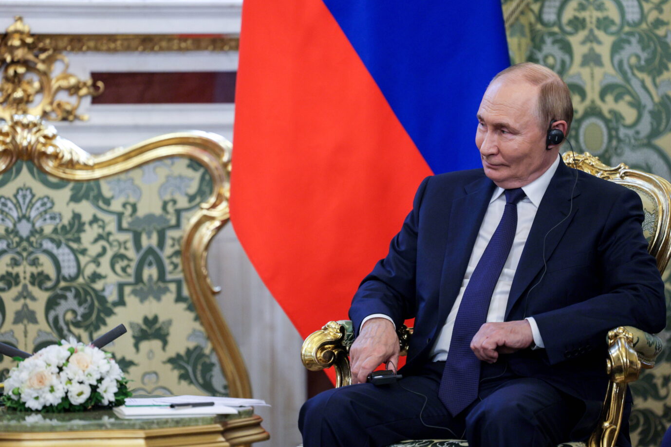 Wladimir Putin sitzt in einem prunkvollen Sessel mit goldenen Verzierungen, vor ihm ein Tisch mit Blumenarrangement; im Hintergrund ist eine russische Flagge zu sehen. Rußlands Präsident Wladimir Putin bei einem Treffen im Kreml: Vor dem Gipfel mit Donald Trump gab es wohl Mißverständnisse in den Vorgesprächen. Foto: IMAGO / ZUMA Press