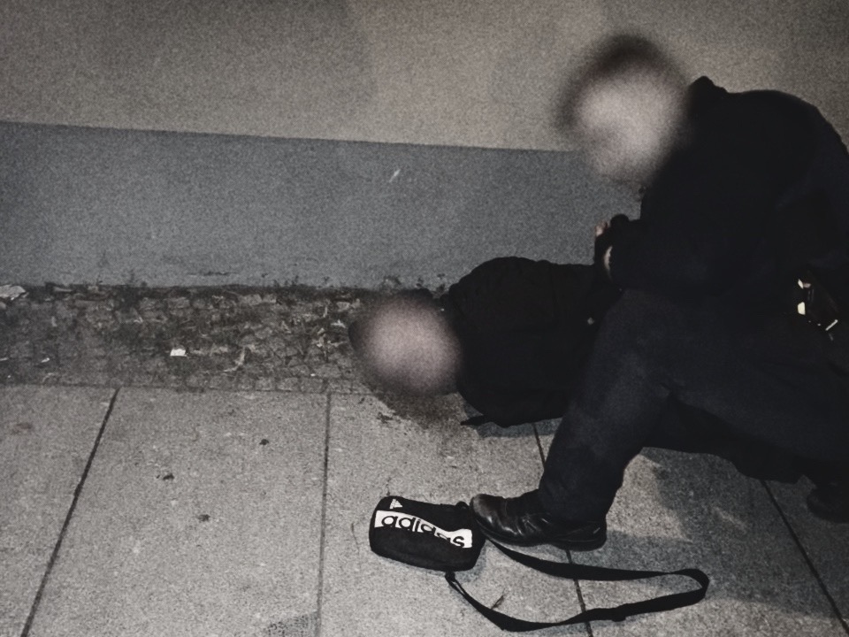 Polizist hält bei einer nächtlichen Festnahme in Nauen einen am Boden liegenden Mann fest; beide Gesichter sind unkenntlich gemacht. Festnahme in Nauen: Die Polizei überwältigte einen 22jährigen, der einen Wahlkampfhelfer der AfD mit einer Machete attackiert haben soll. Foto: Privat