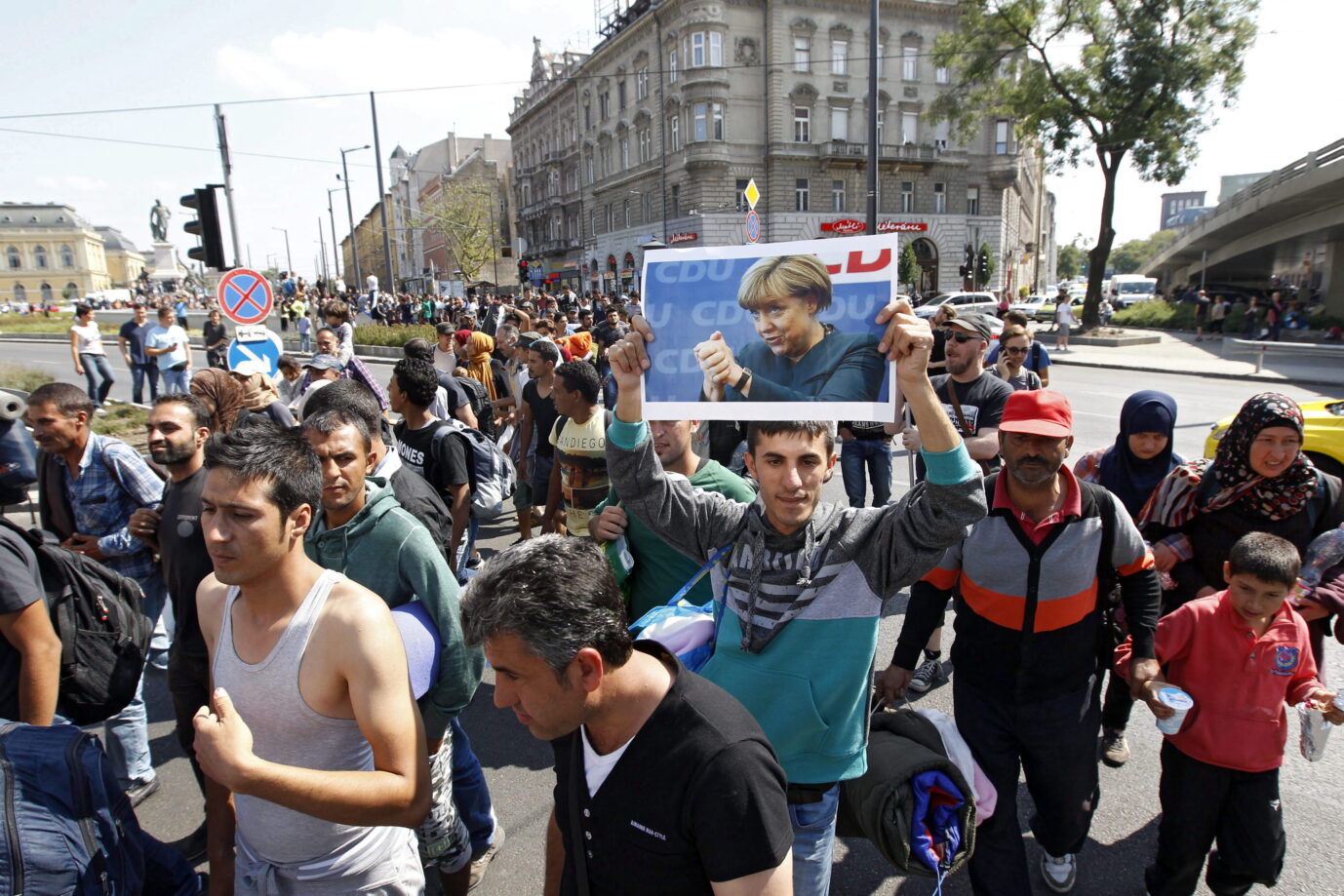 Asylbewerber aus aller Welt stehen am Budapester Bahnhof Keleti am 4. September 2015 und halten ein Bild von Angela Merkel hoch
